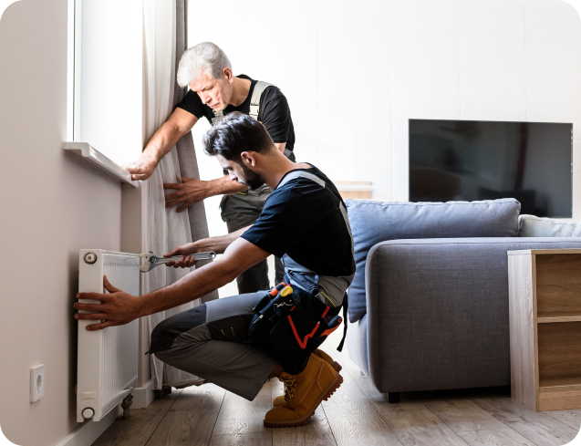 Contractors repairing a heater in a tenant’s home, showing the type of maintenance work that can be logged and managed through Sorto’s property management software.