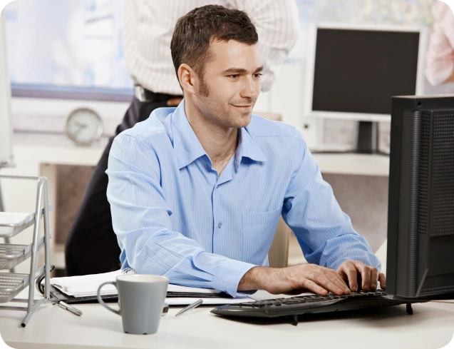 Property manager at a desk managing repairs and maintenance tasks across his property portfolio using Sorto property management software.